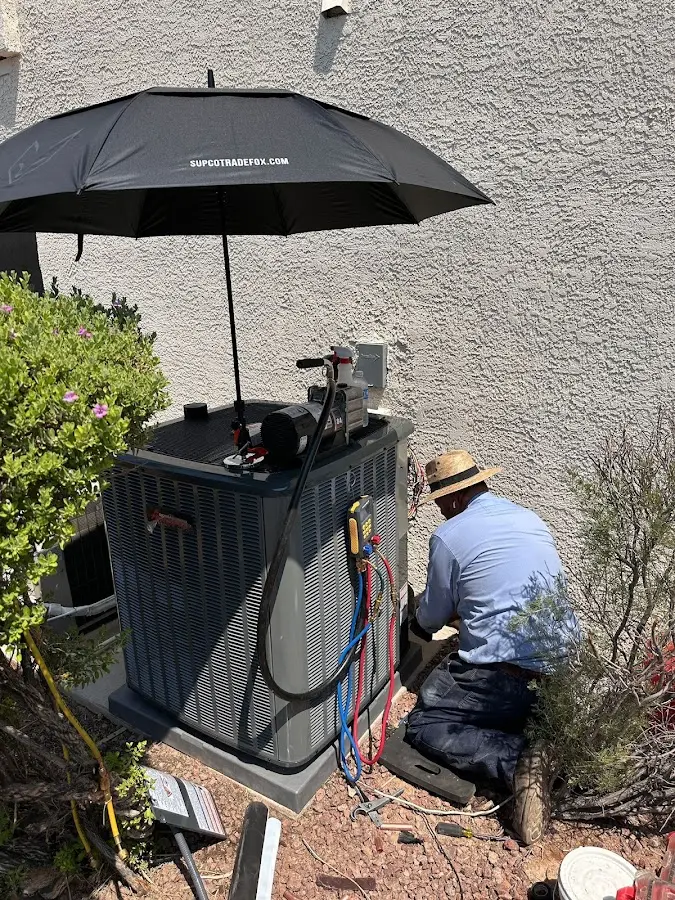 HVAC technician performing outdoor AC maintenance in Fenton
